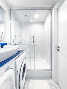 y baño blanco con ducha y lavadora. en Panorama Cental Hotel Batumi, en Batumi