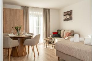a living room with a couch and a table with chairs at Ski Mountain Apartamenty - Plac zabaw - Dmuchaniec - Plac zabaw - Wypożyczalnia rowerów elektrycznych E-Bike Białka in Białka Tatrzańska