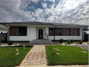 una casa bianca con un mattone di Therme One Level Villas a Baloteşti