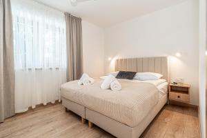 a bedroom with a bed with towels on it at Ski Mountain Apartamenty - Plac zabaw - Dmuchaniec - Plac zabaw - Wypożyczalnia rowerów elektrycznych E-Bike Białka in Białka Tatrzańska