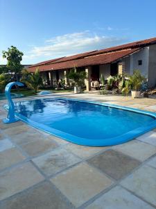 Una gran piscina azul frente a un edificio en Pousada Vila Caburé, en Luís Correia