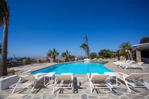 米克诺斯城Villa Ker Scorpio by Bestofmikonos的一个带桌椅的游泳池和一个游泳池