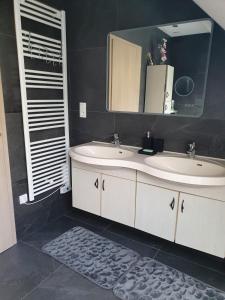 un baño con dos lavabos y un espejo en Maison chaleureuse, en Griesheim-près-Molsheim
