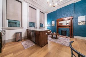 a large kitchen with blue walls and a fireplace at Peacock Suite in Sedalia