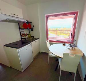 Una pequeña cocina con una mesa y una ventana. en Bright studio with a view of the Black Forest, en Estrasburgo
