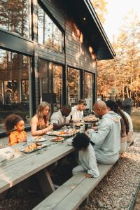 un grupo de personas sentadas en una mesa de picnic comiendo comida en Two Zen Houses - Villas and Spas, en Morin-Heights