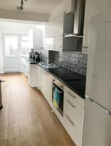 a kitchen with white cabinets and a stove top oven at Cosy 4 Bed House In Solihull Near Town-NEC-BHX in Sheldon