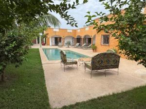 - une piscine avec 2 chaises et une table à côté d'une maison dans l'établissement Villa Warang, à Warang