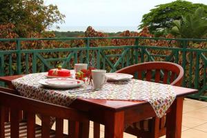 uma mesa de madeira com uma toalha de mesa em cima de uma varanda em Hunters B&B em Mtunzini