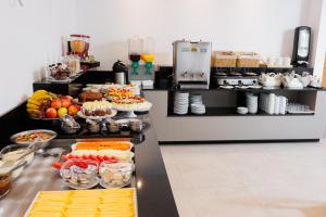 a buffet line with food on it in a restaurant at Luísa Studio Hotel in Florianópolis