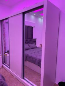 a purple room with a bed and a mirror at عمارة زكي الرمحي 6 in Amman