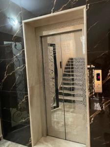 عمارة زكي الرمحي 6 في عمّان: باب زجاجي في الحمام مع هاتف محمول