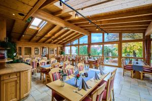 a dining room with tables and chairs and windows at Gasthof Rose in Langenaltheim