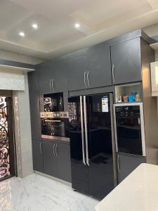 عمارة زكي الرمحي 6 في عمّان: مطبخ بدولاب رمادي وثلاجة
