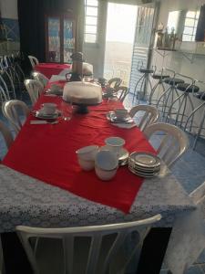 een lange tafel met een rode tafelkleed erop bij Pousada Nossa Senhora Da Polônia in Cachoeira Paulista