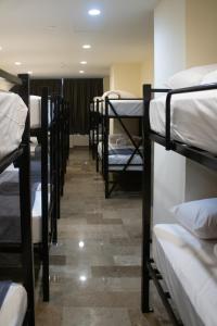 a row of bunk beds in a room at Travohostal Monterrey Historico in Monterrey