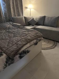 a bed and a couch in a living room at استديو بجلسة بمطبخ مستقل دخول ذاتي 13 in Buraydah