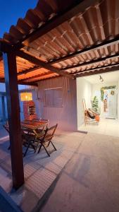 un patio con tavolo, sedie e tetto in legno di REFUGIO DO CRUZEIRO - GRAVATa a Gravatá