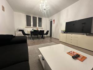 een woonkamer met een bank, een tv en een tafel bij Jonas Haus Gästezimmer in Berlijn