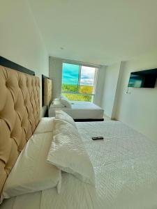 a bedroom with a large bed with a large window at Apartamento de lujo con vista al mar en Karibana in Cartagena de Indias +29 photos
