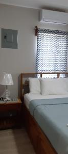 una camera con letto e finestra con lampada di Casa Palma a Placencia