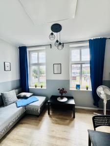 ein Wohnzimmer mit Sofa und Tisch in der Unterkunft Przy Parku Róż II in Chorzów