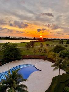 a sunset over a swimming pool at a resort at Apartamento de lujo con vista al mar en Karibana in Cartagena de Indias