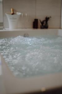 eine Badewanne mit Wasser im Bad in der Unterkunft Luxus-Apartment Champagner&Strafbock in Herford