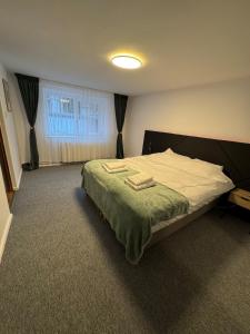 a bedroom with a bed with two towels on it at House in the Heart of Râșnov Old Town in Râşnov