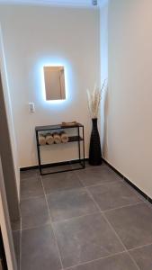 a hallway with a table and a vase with a mirror at Luxus-Apartment Champagner & Spa in Herford +8 photos