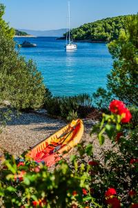 a kayak sitting on a beach next to the water at Luxury Villa Kate - in Lucice Bay with turquoise sea, Amazing Seaviews, and Heated Pool in Milna
