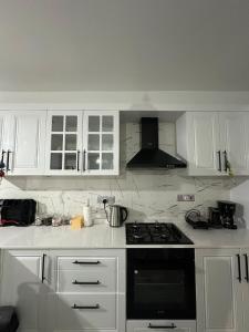 a kitchen with white cabinets and a stove top oven at Moonlight Home in Nicosia +11 photos