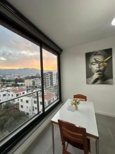 a dining room with a table and a large window at Moonlight Home in Nicosia