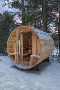 una cabina di legno nel bosco nella neve di Thistle House at Camp Greenwood Vermont with Sauna a Chester