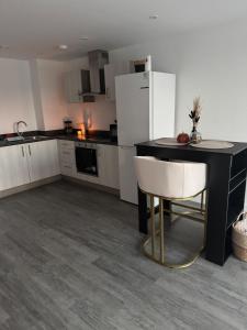 Worcester City Escape في وستر: مطبخ مع طاولة سوداء وثلاجة بيضاء