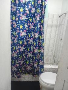 a bathroom with a shower curtain with a toilet at Nature Lodge Retreat in Portland in Port Antonio