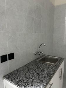 een aanrecht met een wastafel en een tegelwand bij استديو بجلسة بمطبخ مستقل دخول ذاتي 12 in Buraydah