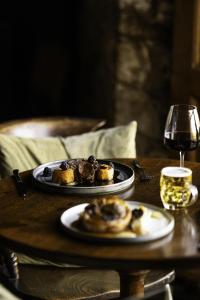 a table with two plates of food and a glass of wine at Winyard's Gap Inn in South Perrott
