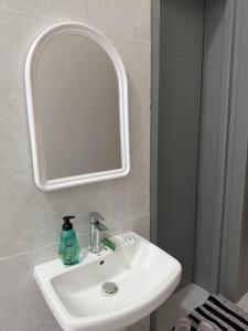 een badkamer met een witte wastafel en een spiegel bij استديو بجلسة بمطبخ مستقل دخول ذاتي 12 in Buraydah