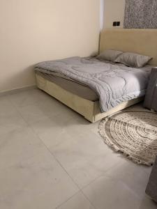een bed in een slaapkamer met een kleed en een bed vierkant bij استديو بجلسة بمطبخ مستقل دخول ذاتي 12 in Buraydah