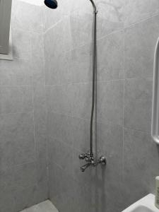 een douche met een douchekop in een badkamer bij استديو بجلسة بمطبخ مستقل دخول ذاتي 12 in Buraydah