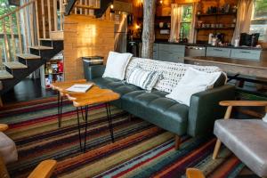 a living room with a green couch and a table at The Cliffside Cabin - Stunning Views in Red River Gorge in Rogers