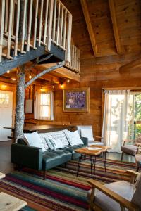 a living room with a couch and a staircase at The Cliffside Cabin - Stunning Views in Red River Gorge in Rogers