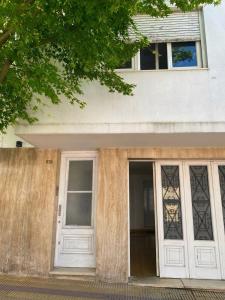 una casa con porte bianche e una finestra di Departamento Constitución a Tandil Altre 4 foto