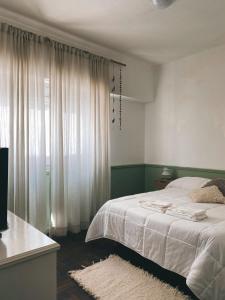 una camera da letto con un letto bianco e una finestra di Departamento Constitución a Tandil
