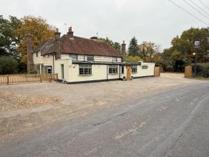 an old white building on the side of a road at The Lord Raglan in Staplehurst