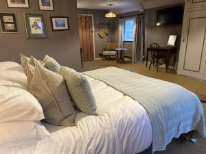 a bed with white sheets and pillows in a bedroom at The Lord Raglan in Staplehurst +4 photos