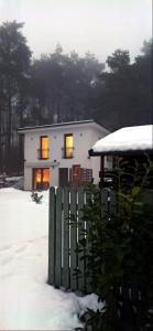 una casa con sus luces encendidas en la nieve en Cicho-Ciszej Dom całoroczny 7-osobowy, en Gąsawa