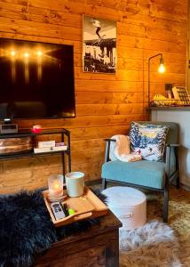 een woonkamer met een tv en een tafel en een stoel bij Cosy Mountain Ski Escape Newly Renovated in Prato Nevoso