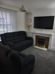 a living room with a couch and a fireplace at Fairy Cove Cottage in Paignton